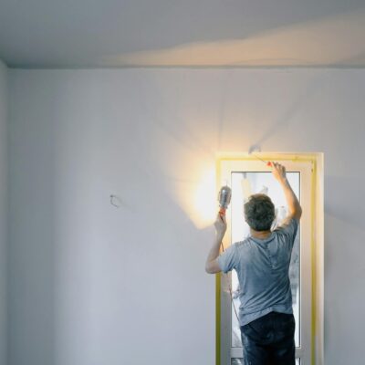 Faceless man repairing door in room